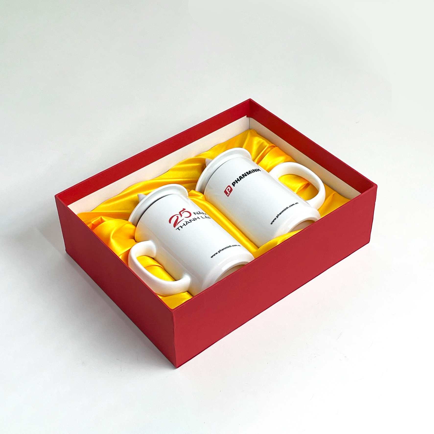 Quà kỷ niệm thành lập công ty: đôi cốc sứ trắng in logo trong hộp cứng nắp rời màu đỏ lót lụa vàng